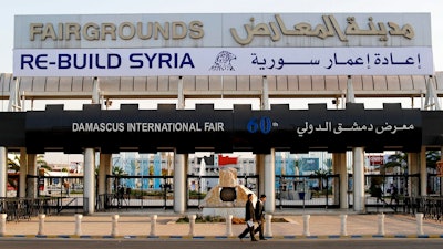 In this Oct. 2, 2018 file photo, Chinese visitors arrive to the opening of the Syria rebuilding exhibition, in Damascus, Syria. The U.S. Embassy in Syria on Wednesday, Aug. 28, 2019 posted a statement on Twitter that warned businesses from outside Syria against participating in an annual trade fare to be held in Damascus. It said anyone doing business with President Bashar Assad's government will expose themselves to the possibility of U.S. sanctions.