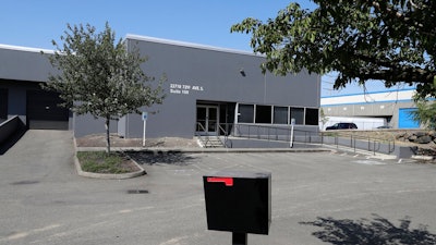 In this Wednesday, July 31, 2019, photo a building that used to house office and storage space for a pawn shop alleged to have been a front for a theft ring stands empty in Kent, Wash. The FBI says the ring sold millions of dollars' worth of stolen goods on Amazon.com in the past six years, and that a pair of Amazon delivery drivers was involved.