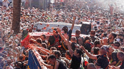 Revellers throw tomatoes at each other during the annual 'Tomatina', tomato fight fiesta in the village of Bunol near Valencia, Spain.
