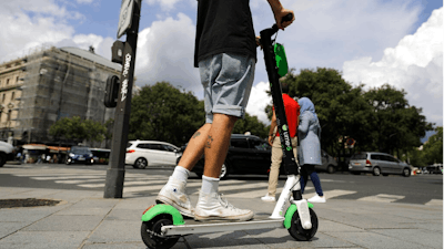 A man rides an electric scooter in Paris, Monday, Aug. 12, 2019. The French government is meeting with people who've been injured by electric scooters as it readies restrictions on vehicles that are transforming the Paris cityscape. The Transport Ministry says Monday's closed-door meeting is part of consultations aimed at limiting scooter speeds and where users can ride and park them.