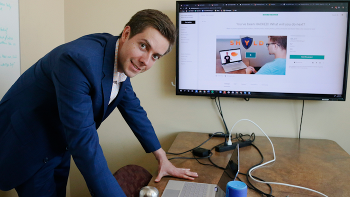Tyler Olson poses in hits office at the University of St. Thomas Minneapolis campus. Olson is just starting a cybersecurity company.