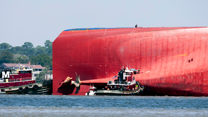 Rescuers work near the stern of the vessel Golden Ray as it lays on its side near the Moran tug boat Dorothy Moran, Monday, Sept. 9, 2019, in Jekyll Island, Ga. Coast Guard rescuers have made contact with four South Korean crew members trapped inside the massive cargo ship off the coast of Georgia.