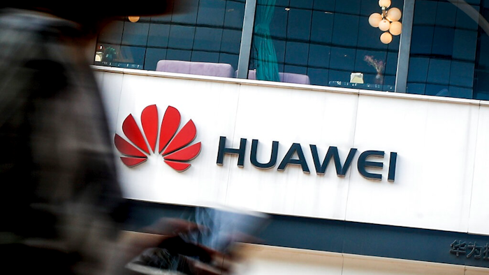 In this July 30, 2019, file photo a woman walks by a Huawei retail store in Beijing. Chinese tech giant Huawei has accused U.S. authorities of trying to coerce employees to gather information on the company and of trying to break into its information systems. The company, the target of U.S. accusations that it is a security threat, said Wednesday, Sept. 4, that American officials were using 'unscrupulous means' to disrupt its business.