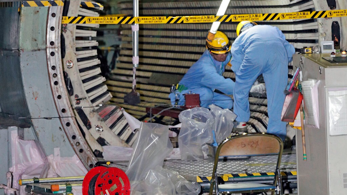 In this Nov. 28, 2018, photo, workers dismantle the Unit 2 reactor at Chubu Electric Power Co.,'s Hamaoka nuclear power plant in Omaezaki, Shizuoka prefecture. Japan's nuclear policy-setting body has adopted a report saying the country is entering an era of massive nuclear plant decommissioning, urging operators to plan ahead to lower safety risks and costs on work requiring decades and billions of dollars.
