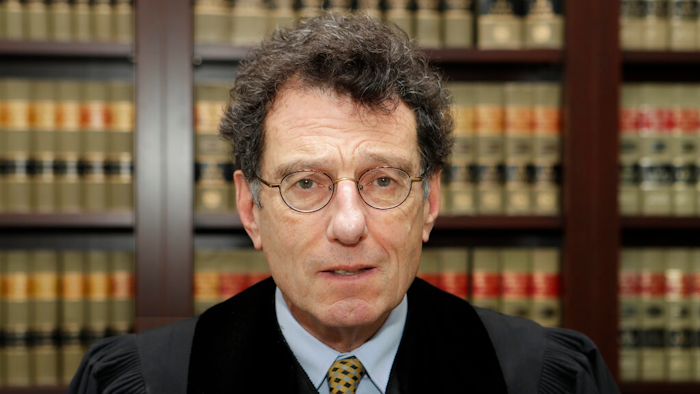 This Jan. 11, 2018 file photo shows Judge Dan Polster in his office, in Cleveland. Attorneys representing eight drug distributors, pharmacies and retailers facing trial for their roles in the national opioid crisis are seeking to disqualify the federal judge overseeing their cases saying he’s shown clear bias in his efforts to obtain a multi-billion dollar global settlement. The motion was filed late Friday, Sept. 13, 2019, in U.S. District Court in Cleveland, where Judge Dan Polster presides over most of the 2,000 lawsuits filed by state, local and tribal governments. Polster has not responded.
