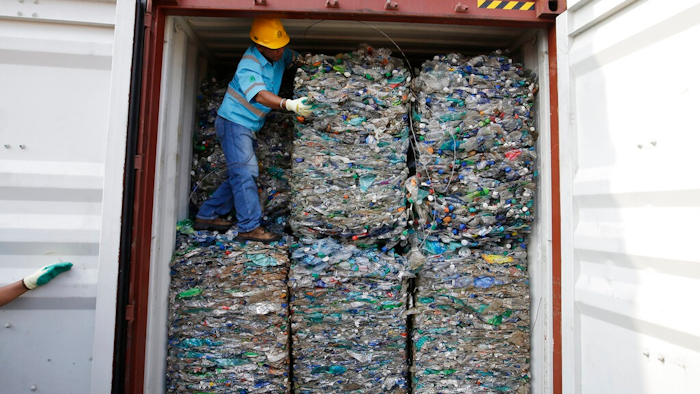 A worker stands inside a container full of plastic waste at Tanjung Priok port in Jakarta, Indonesia Wednesday, Sept. 18, 2019. Indonesia is sending hundreds of containers of waste back to Western nations after finding they were contaminated with used plastic and hazardous materials.