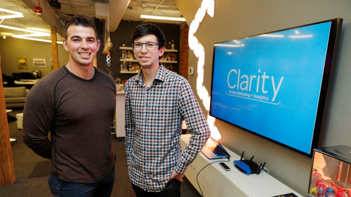 In this Tuesday, Sept. 10, 2019, photo Shane Griffiths, right, and Trenton Erker, left, co-owners of the digital marketing company Clarity Online, pose for a photo in Seattle. Griffiths and Erker use technology for tasks like billing, scheduling appointments, tracking the time they spend on clients' projects and putting together reports on visits to client websites, as well as using freelancers for other tasks as ways to save money on employment costs, and also have more flexibility when they need specific talents or expertise for a project.