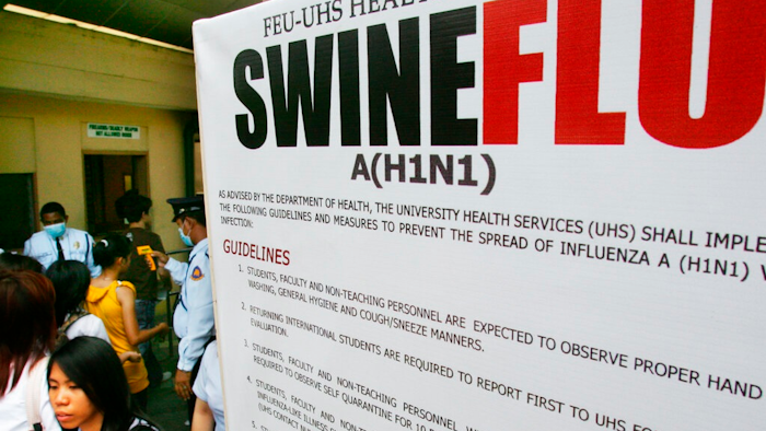 In this June 19, 2009, file photo, a large billboard is displayed at the entrance of a university as security guards use a thermal scanner to check on students temperature before allowing them to enter the school premise in Manila, Philippines. On Monday, Sept. 9, 2019, Philippine officials say lab tests have confirmed African swine fever caused the deaths of pig herds in at least seven villages and a multi-agency force will be set up to try to contain the contagious disease.