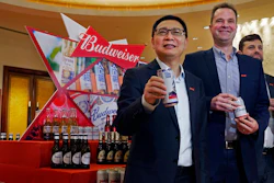 From left, Frank Wang, Executive Director, Jan Craps, Executive Director and CEO and Guilherme Castellan, Chief Financial Officer of Budweiser Brewing Company APAC Limited pose with products in Hong Kong Tuesday, Sept. 17, 2019. AB InBev, the world's largest brewer that produces Budweiser and Corona, has revived plans to list its Asian business in Hong Kong despite persistent pro-democracy protests but halved the size of its initial public offering.