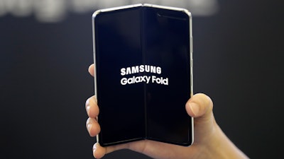 In this Sept. 6, 2019, file photo an employee holds the Samsung Electronics Co.'s Galaxy Fold for a photograph at a shopping mall in Seoul, South Korea. Samsung’s folding phone is finally hitting the U.S. Samsung will start selling the Galaxy Fold, a phone with a screen that folds together like a book, on Friday, Sept. 27.