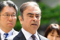 In this May 23, 2019, file photo former Nissan chairman Carlos Ghosn, center, arrives at Tokyo District Court for a pre-trial meeting in Tokyo. Nissan has agreed to pay $15 million and its former chairman Carlos Ghosn is paying $1 million to settle federal regulators' civil fraud charges of hiding from investors more than $140 million in compensation and retirement benefits for Ghosn.