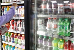 In this Monday, Oct. 1, 2018 file photo, a shop owner reaches into a drink display refrigerator at his convenience store in Kent, Wash. A study on America’s eating habits released on Tuesday, Sept. 24, 2019 shows only slight improvement from 1999 to 2016. While adults cut down a bit on added sugars and ate marginally more whole grains, they still eat too many sweetened foods and unhealthy fats.
