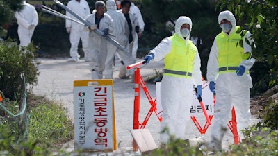 Quarantine officials control access to a pig farm with confirmed African swine fever in Ganghwa, South Korea, Wednesday, Sept. 25, 2019. South Korean on Wednesday said it was intensifying efforts to clean farms around the country as it scrambles to contain the spread of the highly contagious African swine fever that has ravaged farms near its border with North Korea. The notice reads: 'Under quarantine.'