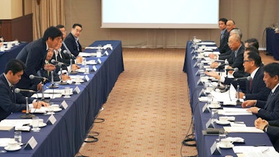 Akio Toyoda, center right, president and CEO of Toyota Motor Corp., with a group of the Japanese automakers chiefs, speaks to Japanese Trade Minister Isshu Sugawara, left standing, during a meeting Thursday in Tokyo.