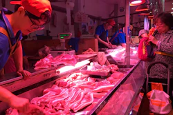 In this Wednesday, Sept. 11, 2019, file photo, a clerk stacks cuts of pork at a meat market in Beijing. China is releasing pork from stockpiles for the second time this month to help cool surging prices ahead of next week’s celebration of the Communist Party's 70th anniversary in power.