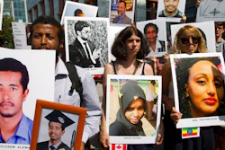 Beza Alemu, left, from Ethiopia, along with other demonstrators, holds pictures of his brother Mulusew Alemu, who died in the plane crash, during a vigil on the six-month anniversary of the crash of a Boeing 737 Max 8, killing 157 people, in Ethiopia on March 10, which has resulted in the grounding hundreds of the planes worldwide, outside of the Department of Transportation, Tuesday, Sept. 10, 2019 in Washington.