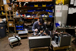 In this Oct. 18, 2018, file photo Minh Pham works on a compressor unit at a commercial refrigeration manufacturing facility in Philadelphia. Small manufacturers and retailers are losing confidence in the national economy yet remain upbeat about their own prospects. That’s the finding of a third quarter survey of 1,000 companies released last week by the U.S. Chamber of Commerce and MetLife.