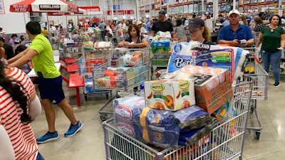 In this Aug. 29, 2019, photo shoppers wait in long lines at Costco in Davie, Fla. On Thursday, Sept. 12, the Labor Department reports on U.S. consumer prices for August.