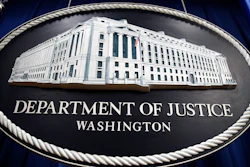 In this Thursday, April 18, 2019, file photo, a sign for the Department of Justice hangs in the press briefing room at the Justice Department, in Washington. The U.S. Justice Department is conducting an antitrust investigation of four automakers that have signed on with California in a deal to toughen tailpipe emissions standards. In July, Ford, Honda, Volkswagen and BMW reached a deal with California to abide by standards that are tougher than those preferred by the Trump administration. The standards are closely linked with fuel economy requirements.