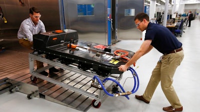 In this Nov. 4, 2016, file photo, a Chevrolet Bolt EV battery pack is removed for testing after undergoing charging and discharging cycles at General Motors Warren Technical Center's Advanced Energy Center in Warren, Mich. If U.S. consumers ever ditch fuel burners for electric vehicles, then the United Auto Workers union is in trouble. Gone would be thousands of jobs at engine and transmission plants across the industrial Midwest, replaced by smaller workforces at squeaky-clean mostly automated factories that mix up chemicals to make batteries.