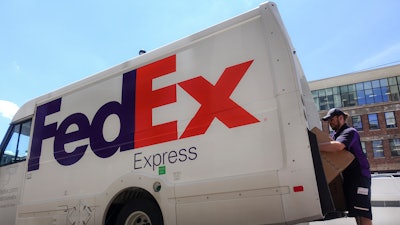 In this file photo a FedEx delivery truck is loaded by an employee on the street in downtown Cincinnati.