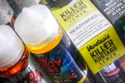 In this Sept. 16, 2019 file photo flavored vaping solutions are shown in a window display at a vape and smoke shop, in New York. Michigan has joined New York in banning the sale of flavored e-cigarettes as federal health officials investigate the cause of hundreds of serious breathing illnesses in people who have used vaping devices. The Michigan Department of Health and Human Services released details of the ban Wednesday, Sept. 18 and gave retailers, including online sellers, two weeks to comply. The ban includes menthol and mint flavored products.