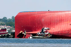 Rescuers work near the stern of the vessel Golden Ray as it lays on its side near the Moran tug boat Dorothy Moran, Monday, Sept. 9, 2019, in Jekyll Island, Ga. Coast Guard rescuers have made contact with four South Korean crew members trapped inside the massive cargo ship off the coast of Georgia.