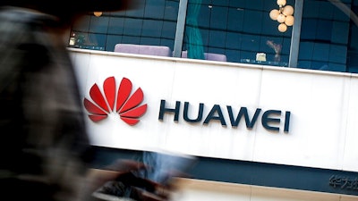 In this July 30, 2019, file photo a woman walks by a Huawei retail store in Beijing. Chinese tech giant Huawei has accused U.S. authorities of trying to coerce employees to gather information on the company and of trying to break into its information systems. The company, the target of U.S. accusations that it is a security threat, said Wednesday, Sept. 4, that American officials were using 'unscrupulous means' to disrupt its business.
