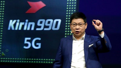 Richard Yu, CEO of the Huawei consumer business group, holds a 'Kirin 990 5G' processor during a keynote at the IFA 2019 tech fair in Berlin, Germany, Friday, Sept. 6, 2019. The IFA takes place in Berlin from Sept. 6 until Sept. 11, 2019.