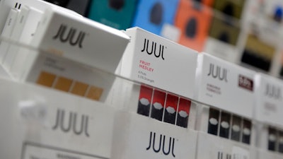 In this Dec. 20, 2018, file photo Juul products are displayed at a smoke shop in New York. Federal health authorities say vaping giant Juul Labs illegally promoted its electronic cigarettes as a safer option to smoking, including in a presentation to school children. The Food and Drug Administration issued a stern warning letter to the company Monday, Sept. 9, 2019, flagging various claims by Juul, including that its products are “much safer than cigarettes.” The FDA has been investigating Juul for months but had not previously warned the company.