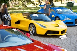 People looking at a Aston Martin One-77 Coupe (2011) in front of a Ferrari LaFerrari (2015), yellow, and a Bugatti Veyron EB 16.4 Coupe (2010), blue, part of some 25 luxury cars owned by Teodoro Obiang, the son of the Equatorial Guinea's President Teodoro Obiang Nguema Mbasogo are pictured before an auction of sales house Bonhams at the Bonmont Abbey Golf & Country Club in Cheserex near Geneva, Switzerland, Sunday, Sept. 29, 2019. A collection of luxury cars from Equatorial Guinea's vice president Teodorin Obiang Nguema confiscated by the Geneva prosecutor's office after a deal ending a money-laundering inquiry, are auctioned off in Switzerland and are estimated to bring in 18.5 million Swiss francs.