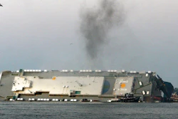 In this Sunday, Sept. 8, 2019 photo, smoke rises from a cargo ship that capsized in the St. Simons Island, Ga., sound. Authorities say oil from an overturned cargo ship has reached several parts of Georgia’s shoreline, leaving a sheen in marshes and oiled debris on beaches.