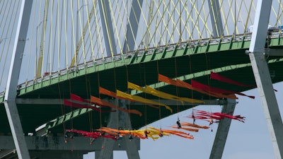 Greenpeace USA protesters dangle from the Fred Hartman Bridge Thursday, September 12, 2019, in Baytown, Texas. A portion of the Houston Ship Channel has closed after about a dozen Greenpeace USA activists protesting the use of fossil fuels suspended themselves from a bridge ahead of a Democratic presidential debate.