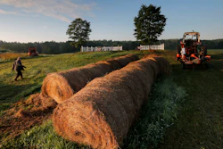 Dairy farmer Fred Stone walks to his baling machine at his dairy farm in Arundel, Maine.