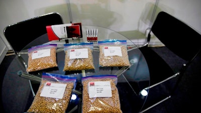 In this April 12, 2018, file photo, packets of raw soybeans are placed on a table at a U.S. soybean company's booth at the international soybean exhibition in Shanghai, China. China has announced some U.S. industrial chemicals will be exempt from tariff hikes imposed in a trade war with Washington but maintained penalties on soybeans, pork and other farm goods. The Ministry of Finance's announcement Wednesday, Sept. 11, 2019 came ahead of October talks aimed at ending the fight over trade and technology that threatens global economic growth.