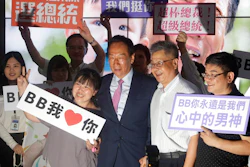 In this June 21, 2019, file photo, Terry Gou, center, chairman of Foxconn, the world's largest contract assembler of consumer electronics, poses with supporters for a photo after the company's annual shareholders meeting in New Taipei City, Taiwan. Gou has given up on making a bid for Taiwan's presidency. Gou announced his decision in a statement late Monday, Sept. 16, 2019, one day before a deadline to register for the race.