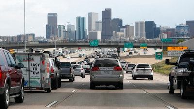 In this Thursday, July 11, 2019, file photograph, southbound Interstate 25 traffic lanes bog down to a crawl at the interchange with Interstate 70 just north of downtown Denver. On Friday, Sept. 6, 2019, the U.S. Environmental Protection Agency held a hearing to decide whether to lower the ozone status of Denver and eight other northern Colorado counties from 'moderate' to 'serious,' a move that would force the state to take action to clean the air but which businesses have voiced objections over meeting any possible regulatory changes.