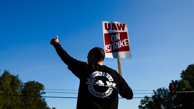 A worker gives the thumbs-up gesture to a passing motorist as he demonstratives outside a General Motors facility in Langhorne, Pa., Tuesday, Sept. 17, 2019. More than 49,000 members of the United Auto Workers walked off General Motors factory floors or set up picket lines early Monday as contract talks with the company deteriorated into a strike.