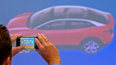In this Tuesday, May 14, 2019 file photo, a journalist takes photographs during a presentation of the new electric 'ID.3' car at a press tour of the plant of the German manufacturer Volkswagen AG (VW) in Zwickau, Germany. Volkswagen is rolling out what it bills as the breakthrough electric car for the masses, the leading edge of a wave of new battery-powered vehicles about to hit the European auto market. The ID.3 is going on display ahead of the Frankfurt Motor Show on Monday Sept. 9, 2019.
