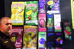 Sgt. Christopher Hannah of the Kenosha County Sheriff's Department stands in front of a display of the colorfully packaged vaping products during a news conference in Kenosha Wednesday, Sept. 11, 2019.