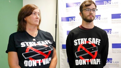 Adam Hergenreder, right, and his mother Polly, attend a news conference where their attorney announced the filing of a civil lawsuit against e-cigarette maker Juul on Hergenreder's behalf Friday, Sept. 13, 2019, in Chicago. The lawsuit filed Friday in Lake County, Illinois, Circuit Court alleges Juul Labs, Inc., deliberately targeted young people through Instagram and other sites to suggest vaping can boost their social status. It also says Juul doesn't fully disclose their products contain dangerous chemicals.