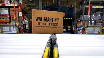 In this Nov. 9, 2018, file photo, a box of merchandise is unloaded from a truck and sent along a conveyor belt at a Walmart Supercenter in Houston. Walmart is rolling out an unlimited grocery delivery subscription service this fall for a $98 annual fee. The service will reach 1,400 stores in 200 markets and allows the nation’s largest grocer to further tap into time-starved shoppers looking for convenience.