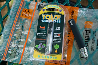 A Yolo! brand CBD oil vape cartridge sits alongside a vape pen on a biohazard bag. Jay Jenkins says two hits from the vape put him in a coma and nearly killed him in 2018.