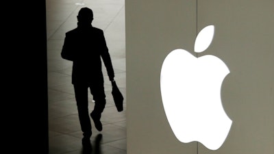 In this Jan. 3, 2019, file photo a man leaves an Apple store in Beijing. Apple on Tuesday, Sept. 10, is expected to unveil three new iPhone models that are so similar to last year’s lineup, they may be upstaged by details about the company’s upcoming video service.