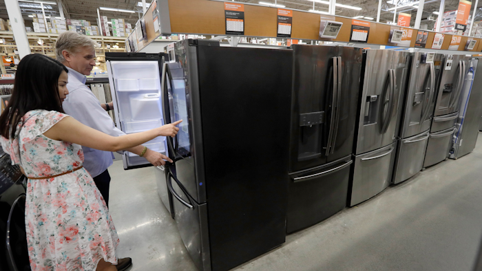 In this Sept. 23, 2019 photo, shoppers examine refrigerators at a Home Depot store location, in Boston.