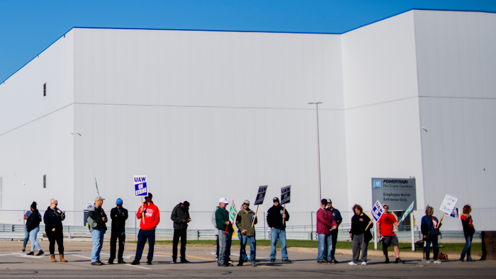 General Motors' Flint Assembly Plant employees line the street with picket signs during the nationwide UAW strike against General Motors on Monday, Oct. 7 in Flint, MI.