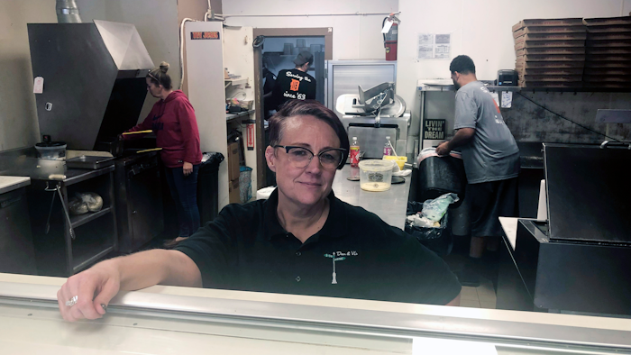 Tina Wheeler, manager of Dan and Vi's pizza poses for a photo Thursday in Detroit. Dan and Vi’s pizza deli, one of the few eateries near the Detroit-Hamtramck General Motors plant, says sales have been down, though Wednesday’s noontime crowd snaked around the small shop nearly to the door.