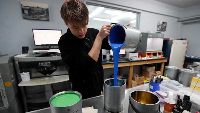 Harvey Myland prepares paint for mixing at the factory in London on Thursday, Oct. 24.