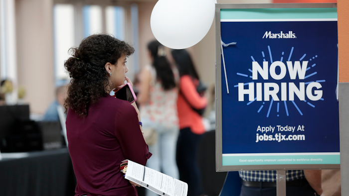 In this Oct. 1, 2019 file photo, Daisy Ronco waits in line to apply for a job with Marshalls during a job fair at Dolphin Mall in Miami.