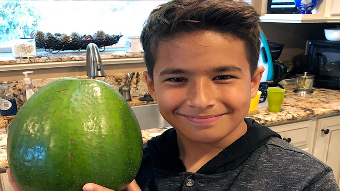 Lo'ihi Pokini poses with the Guinness World Record Heaviest Avocado at Kula Country Farms in Kula,Hawaii.